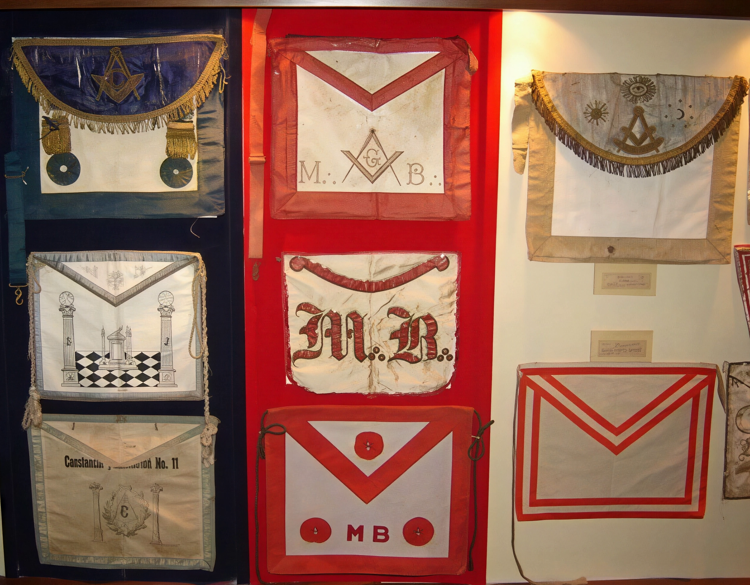 A la izquierda, antiguos mandiles usados por las Logias del Rito de York. Al centro, tres versiones de los mandiles de M.·. M.·. del R.·.E.·.A.·. y A.·. usados en diversas épocas. A la derecha, en la parte superior, un mandil del Rito de York con babeta semicircular del Siglo XIX; en la parte inferior, un mandil usado en las Tenidas y Grandes Asambleas de la Gran Logia del Perú.